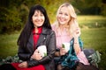 Two young women have a good time in a city park. Girlfriends in a city park on a picnic on a warm evening at sunset. Royalty Free Stock Photo