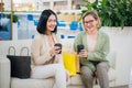 Two young women having coffee break together at shopping mall Royalty Free Stock Photo