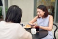 Two young women having coffee break together use smart phone. Happy women using cell phone at sidewalk cafe