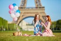 Two young women having picnic near the Eiffel tower in Paris, France Royalty Free Stock Photo