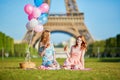 Two young women having picnic near the Eiffel tower in Paris, France Royalty Free Stock Photo