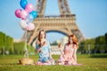 Two young women having picnic near the Eiffel tower in Paris, France Royalty Free Stock Photo