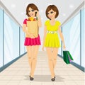 Two young women holding grocery shopping paper bags walking in supermarket Royalty Free Stock Photo