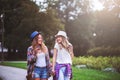 Two young women holding hands walking in green park. Best friends Royalty Free Stock Photo