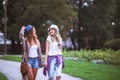 Two young women holding hands walking in green park. Best friends Royalty Free Stock Photo