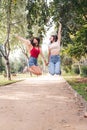 two young women jumping with joy holding hands Royalty Free Stock Photo