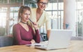 Two young women learning online together. Education for adults. Film effect.Girls blogging, learning,booking online. Royalty Free Stock Photo