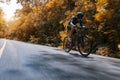 Cycling training, Cyclist speeding mountain bike on road with autumn forest side. Royalty Free Stock Photo