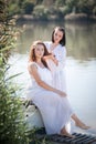 Two young women in long white dresses near the river Royalty Free Stock Photo