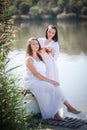 Two young women in long white dresses near the river Royalty Free Stock Photo
