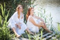 Two young women in long white dresses near the river Royalty Free Stock Photo