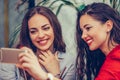 Two young women looking at mobile phone and smiling Royalty Free Stock Photo
