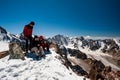Two young women and man trekkers resting on top of Pik Uchitel peak . Ala Archa Alpine National Park Landscape near Bishkek, Tian