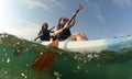Two young women paddling blue kayak