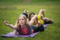 Two young women performs training for flexibility in the park