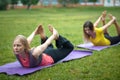 Two young women performs training for flexibility in the park