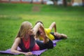 Two young women performs training for flexibility in the park