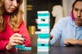 Two young women playing colored jenga