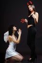 Two women posing in angel and demon costumes Royalty Free Stock Photo