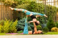 Two young women practicing acro yoga outdoors