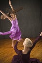 Pair of young women in dresses dancing in the studio.