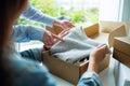 Women receiving and opening a postal parcel box of clothing at home for delivery and online shopping concept