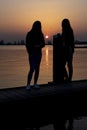 Two young women relaxing during  sunset on a landing stage at the Lake Zoetermeerse Plas in Zoetermeer, The Netherlands 3 Royalty Free Stock Photo