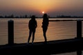 Two young women relaxing during  sunset on a landing stage at the Lake Zoetermeerse Plas in Zoetermeer, The Netherlands 1 Royalty Free Stock Photo