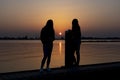 Two young women relaxing during  sunset on a landing stage at the Lake Zoetermeerse Plas in Zoetermeer, The Netherlands 2 Royalty Free Stock Photo