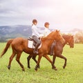 Young women riding horses on mountain meadow Royalty Free Stock Photo
