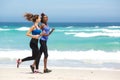 Two young women running along the beach Royalty Free Stock Photo