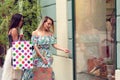 Two women in shopping looking at shop window in the city Royalty Free Stock Photo