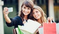 Two young women shopping at the mall taking a Royalty Free Stock Photo