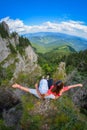 Two young women sitting on a cliff edge in the Ceahlau mountains in Romania Royalty Free Stock Photo