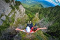 Two young women sitting on a cliff edge in the Ceahlau mountains in Romania Royalty Free Stock Photo