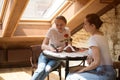 Two young women sitting at table in cafe and look at the phone. Business meeting freelancers Royalty Free Stock Photo