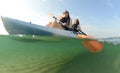 Two young women smiling in blue kayak