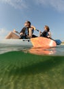 Two young women smiling in blue kayak