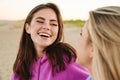 Two young women smiling and looking at each other on beach Royalty Free Stock Photo