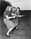 Two young women and a soldier trying out a machine gun Royalty Free Stock Photo