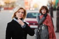 Two young fashion women walking on a city street Royalty Free Stock Photo