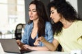 Two young women studying with a laptop computer.