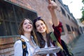 Two young women tourist using their map in the city.