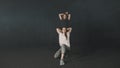 Two young women training a synchronous dance choreography in dark studio