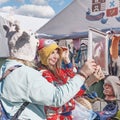 Two young women trying on funny felted wool hats at traditional Irbit fair, Russia Royalty Free Stock Photo
