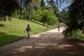 Two young women walking down a park alley in Madrid