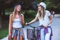 Two young women holding hands walking in green park. Best friends Royalty Free Stock Photo