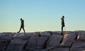 Two young women in winter clothing on boulder walkway