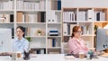 Two young women working together in modern startup office, sitting side by side and concentrating on their computers. The image Royalty Free Stock Photo