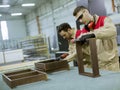 Two young workers assembling furniture in the factory Royalty Free Stock Photo